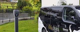 Electric charging station next to the Chäs Stuba electric bus at Sunstar Hotel Klosters – sustainable mobility in everyday hotel operations.